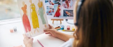Back view of a young designer creating a new collection for women in her at-home studio